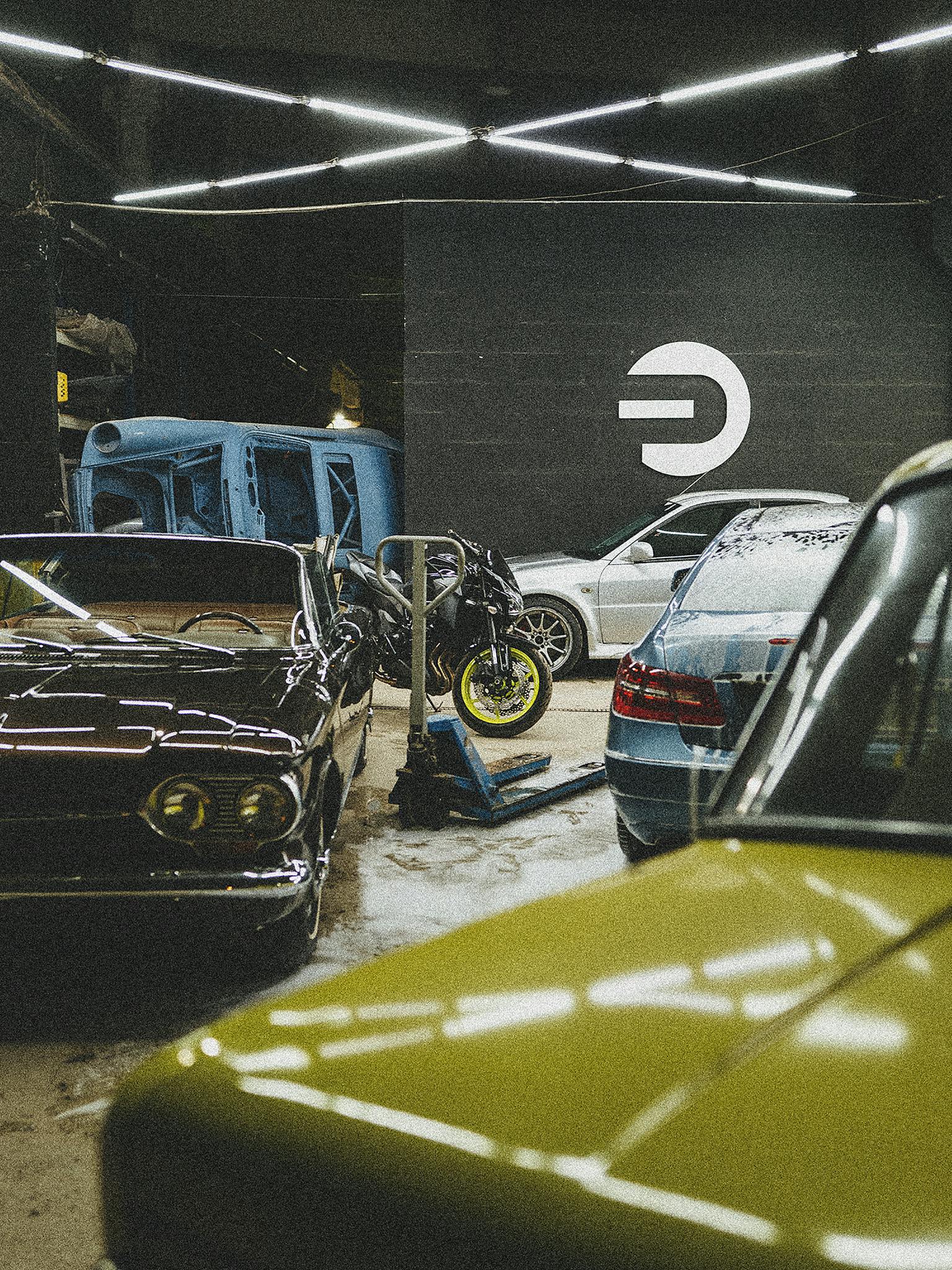 Indoor garage showcasing diverse parked vehicles and unique design elements.